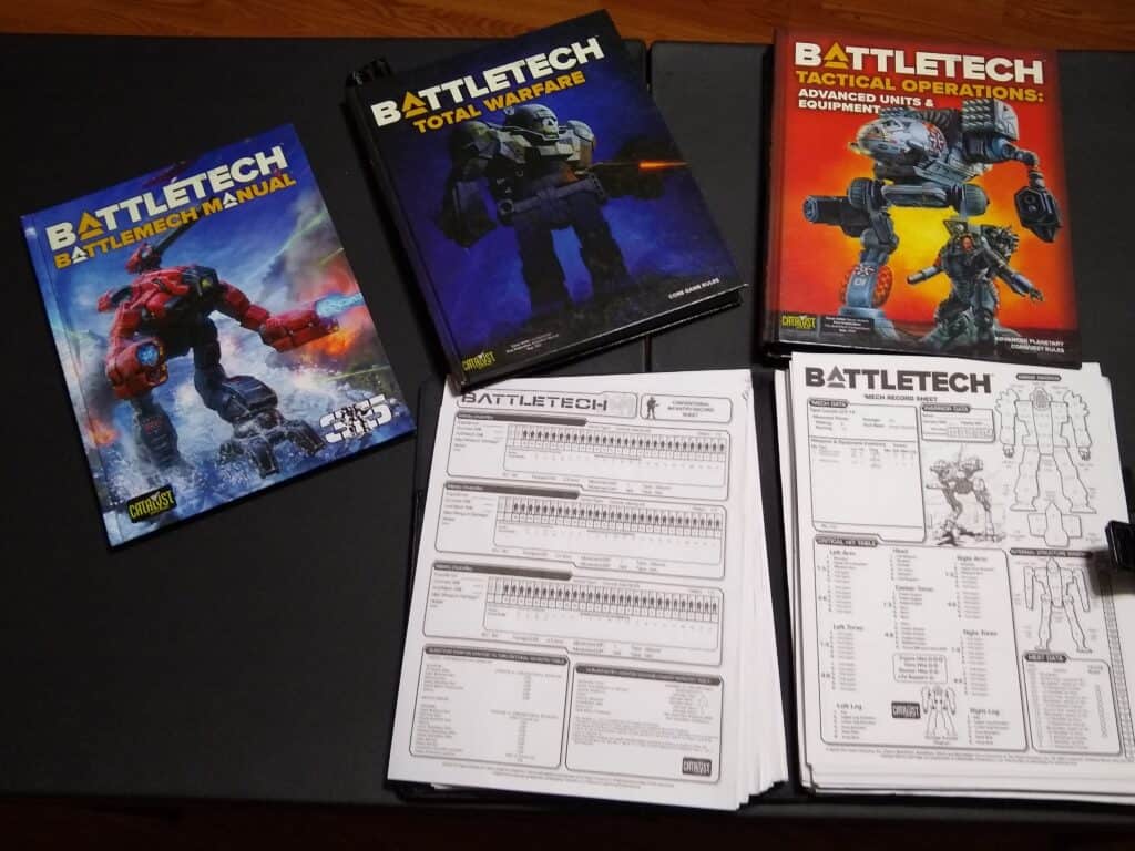 Battletech rulebooks and record sheets on table